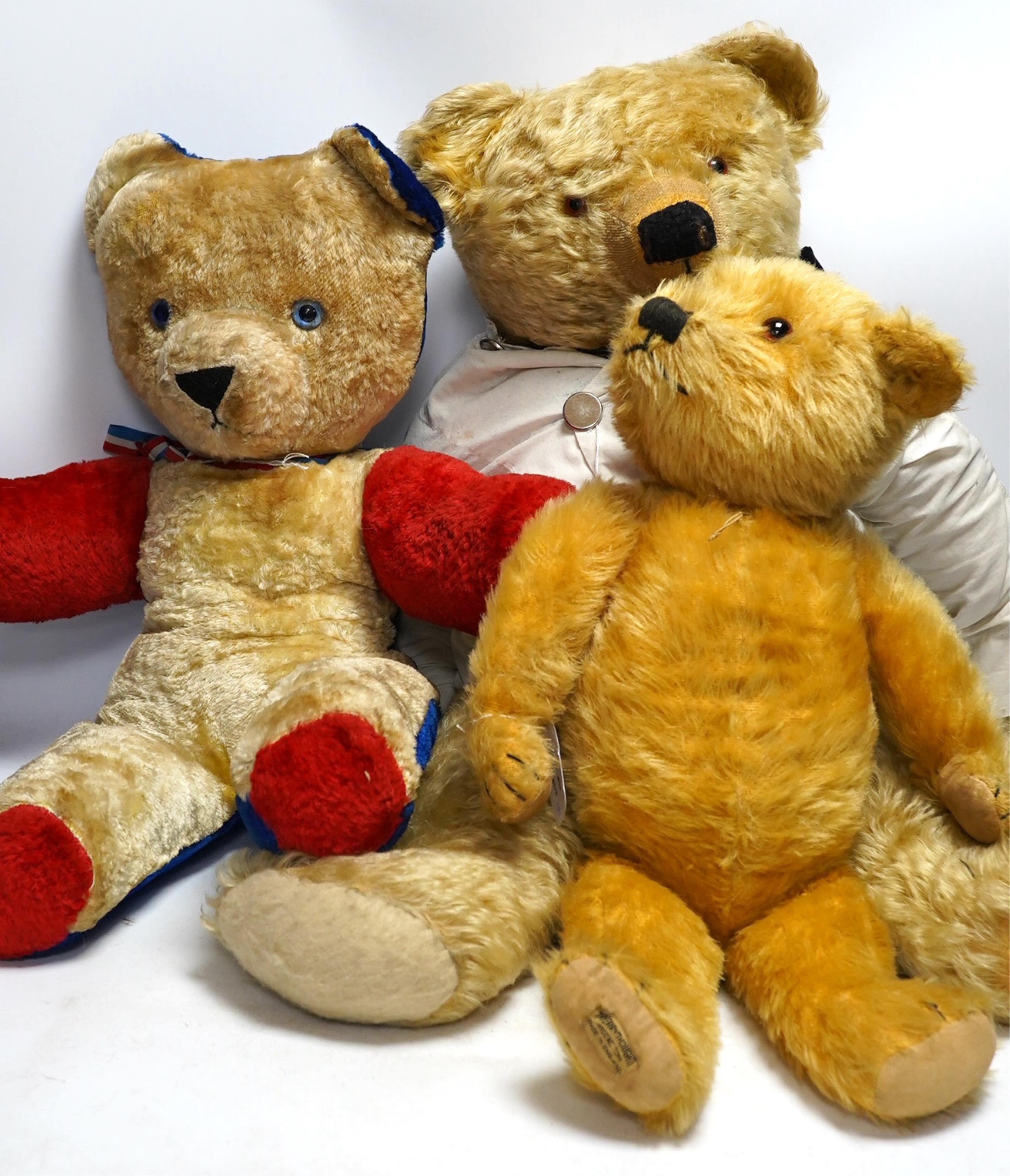 A large Chad Valley bear, c.1930's, label on foot, hair loss, restored paw pads, 69cm high, a Chad Valley red, white and blue unjointed bear, c.1950's, 60cm high, and a Merrythought bear c.1930's, label on foot, slight h